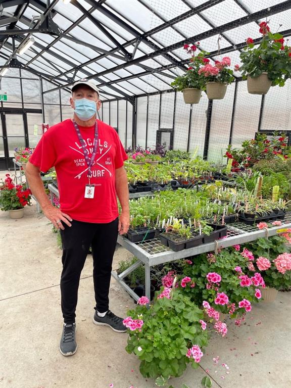 Andy Paling next to plants in greenhouse